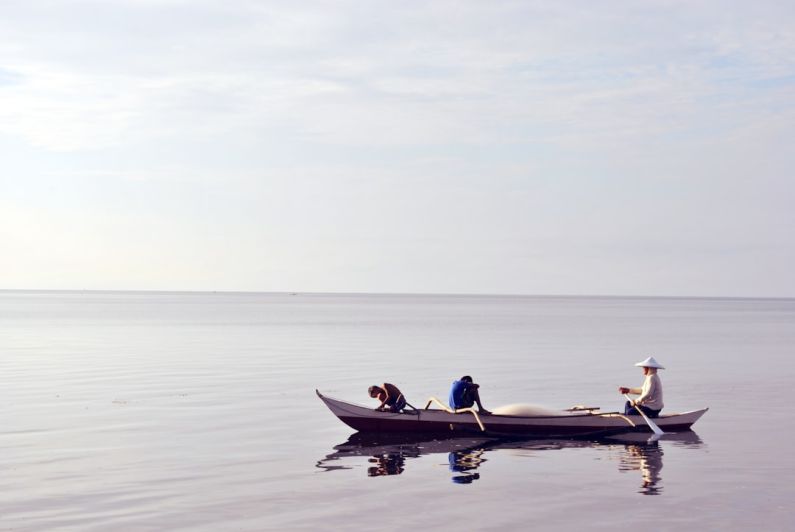 Rowing Boat - three person riding canoe at sea