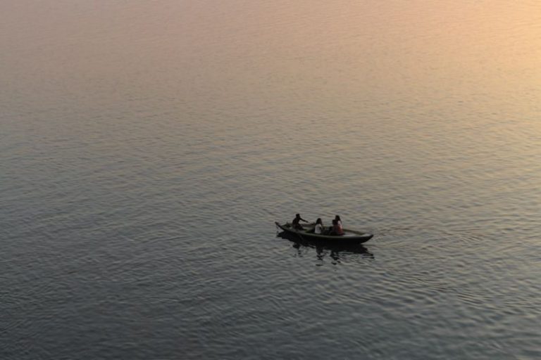Rowing Boat - three person riding on boat surrounded by water during golden hour