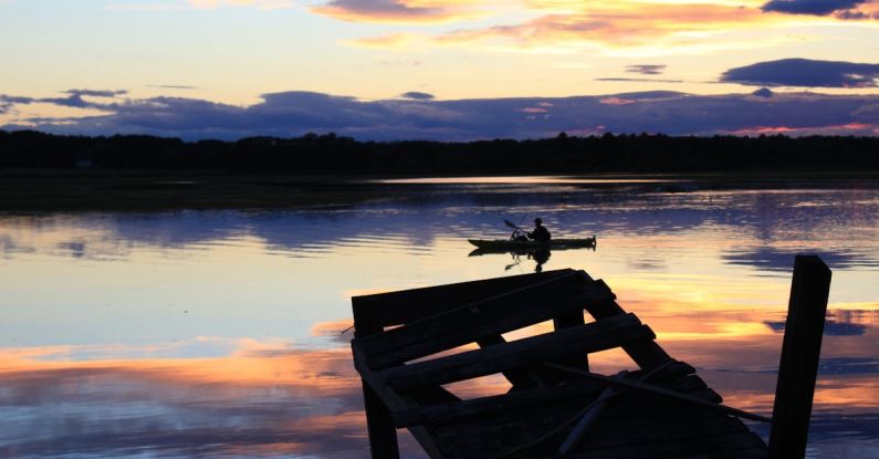 Rowing - Person Riding Boat on Body of Water