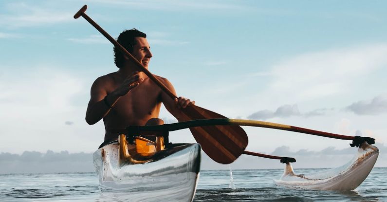 Rowing - Man Riding on Boat Holding Brown Paddle
