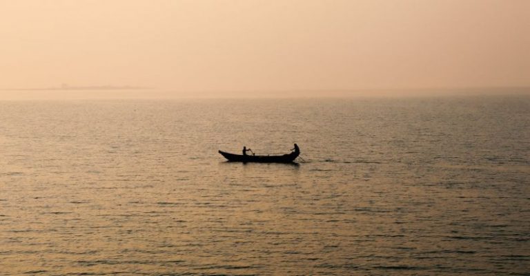 Rowing - Silhouettes of People Rowing Canoe across Sea